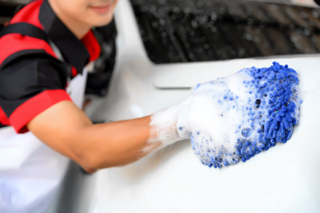 Man Worker use Soap Washing and Taking Care of Vehicle car body with Diligence, Car Washing and Detailing to Shiny and Clean Vehicles for Automotive Maintenance.の写真素材