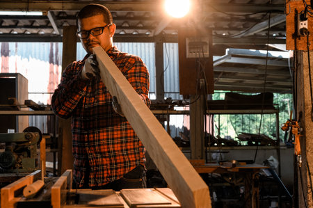 Asian carpenter craftsmen check lines of wood before cutting plank wood with machine electronic...