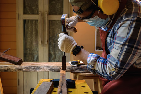 Carpenter hand with chisel in hand working on carpentry. Carpenter use chisel making to wooden...