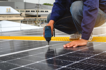 Technician Using Tool Installing Solar Panel or Photovoltaic at Support Point in Daytime on Factory...