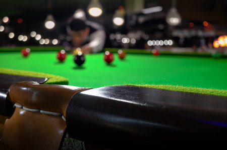 Pockets at the edge of snooker table are goal of black balls with aiming ball of the snooker player blurred in the background. Selective focusing on leather fabric pockets of snooker table.の写真素材