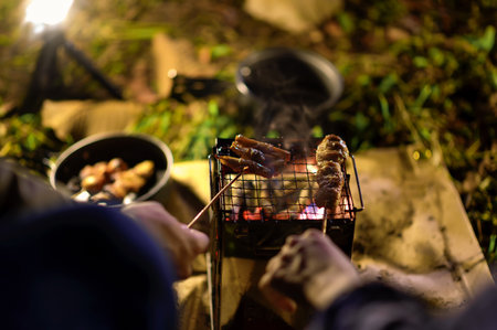 Close-up of barbecue meal grill in the wilderness of backpacker group. Grilled meals ready to eat for hiking groups, Camping in nature, Cooking at night with an atmosphere that is warm and inviting.の写真素材