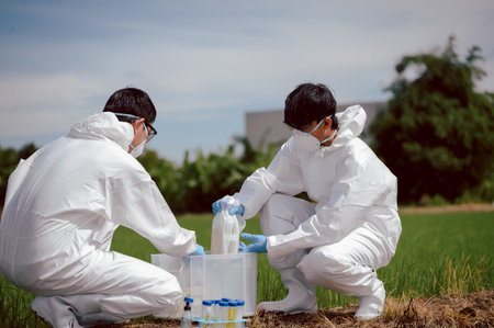 Factory scientists or biologists wear protective clothing while checking natural water sources,...