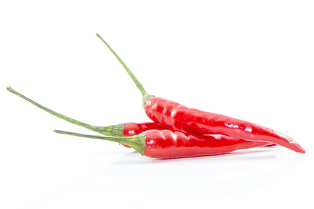 Red cayenne peppers with green branch on white backgroundの写真素材