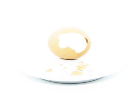 Peel eggshell on white plate on white backgroundの写真素材