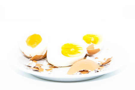 Boiled egg sliced on white plate on white backgroundの写真素材