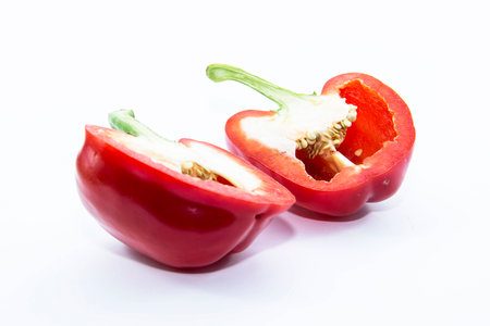 Organic red bell chili half sliced on white background