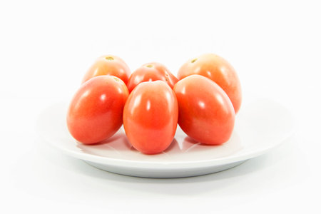 Organic tomatoes on white plate and white backgroundの写真素材