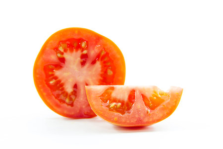 Red tomato pieces sliced ingredient on white backgroundの写真素材