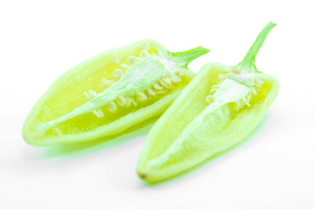 Green chili pepper half cut with seed on white backgroundの写真素材