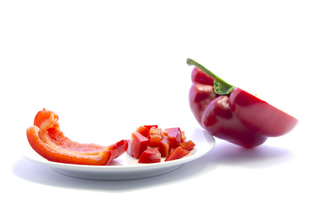 Dice red bell chili cutting and sliced fresh ingredient on white plate and white backgroundの写真素材