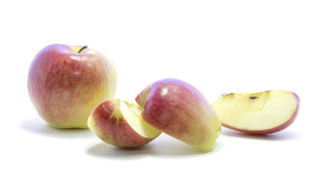 Red yellow apple size cut half and quarter sliced on white backgrounの写真素材