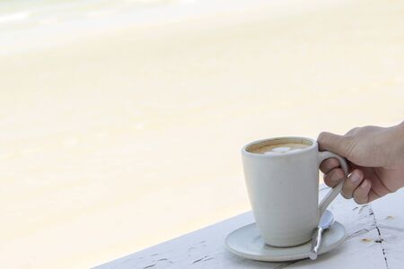 Drink Coffee latte cup close to brown beach in summerの写真素材