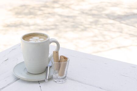 Coffee latte cup with snack under shade and tree shadowの写真素材
