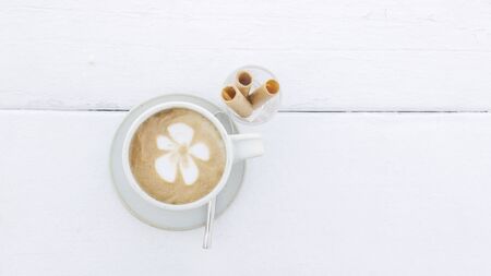 Coffee latte cup with snack top view on white backgroundの写真素材
