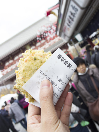 Mochi crispy fried traditional street food in Japan cover with small paperの写真素材