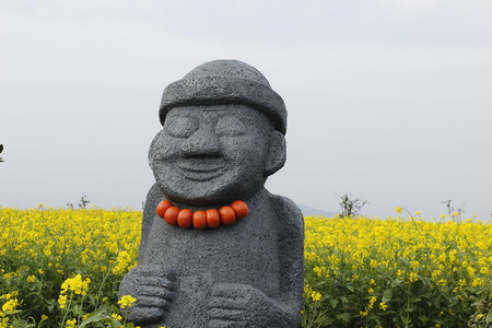 Hareubang black stone statue with yellow background in Jeju island Koreaの写真素材