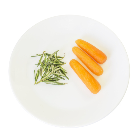 Green rosemary leaves and baby carrots  ingredient top view on white plate and white backgroundの写真素材