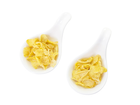 Corn flake in spoon on top view and white backgroundの写真素材