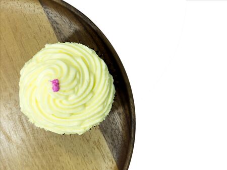 Vanilla cup cake topping with milk cream top view on wood plate isolatedの写真素材