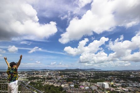Traveler man enjoy with city scenery on blue sky backgroundの写真素材