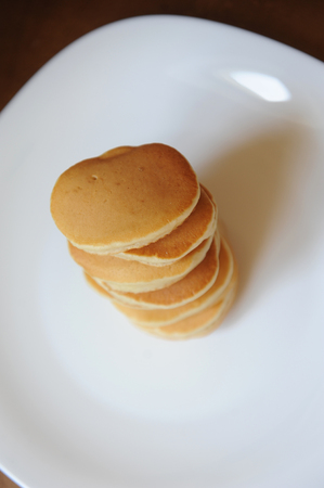 Homemade sweet pancakes on a white plate, top viewの写真素材