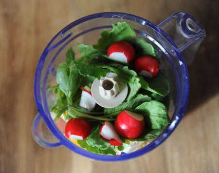 Radish with greens in bowl blender, top view. Preparation of smoothiesの写真素材
