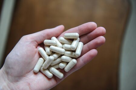 Handful of pills capsules in hand close-upの写真素材