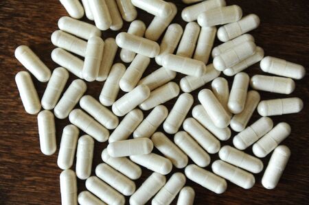 Placer of capsule tablets on wooden background close upの写真素材