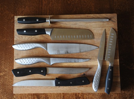 Set of kitchen knives and moussat on wooden cutting board, top viewの写真素材