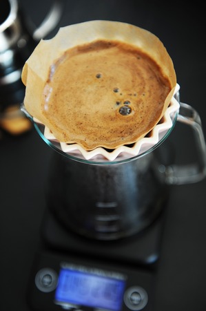 Alternative filter black coffee brew with pink origami dripper. Electronic timer scale. Specialty conceptの写真素材