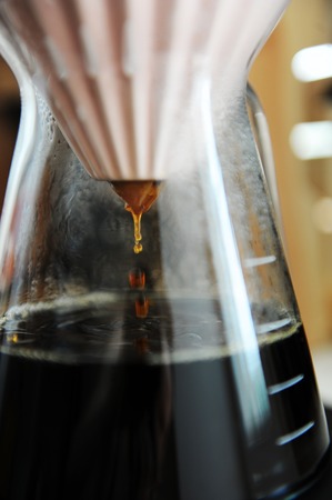 Alternative filter black coffee pour over brewing with pink origami dripper. Specialty concept. Dripping close upの写真素材