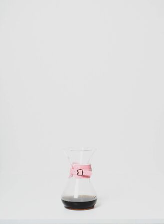 Glass coffee jug with pink holder isolated
