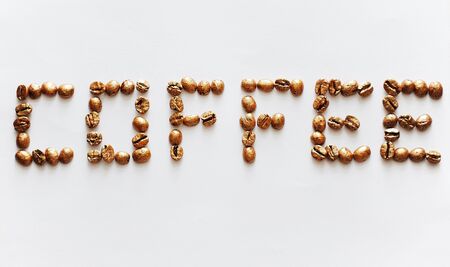 Lettering Coffee made of golden pearl coffee beans on white background. Expensive coffee concept