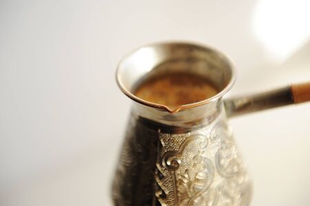 Cooper cezve coffee brewing on white background closeupの写真素材