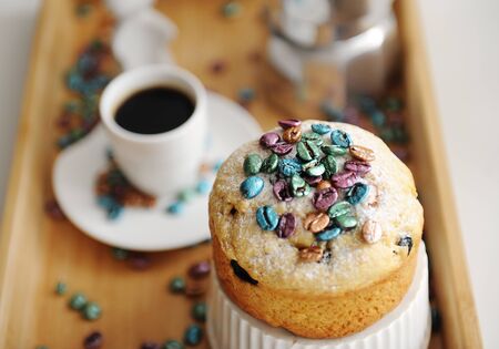 Easter cake sprinkled colored pearl coffee beans close up. Espresso maker moka pot and cup of coffee...