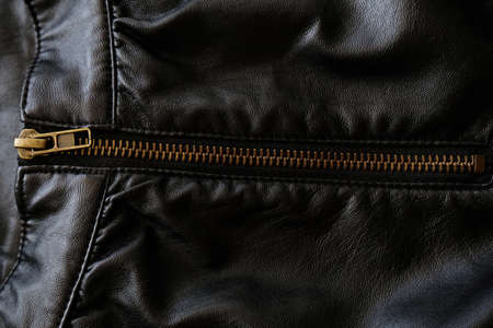 Black leather fabric with zippers, background. Fashion design clothing detail