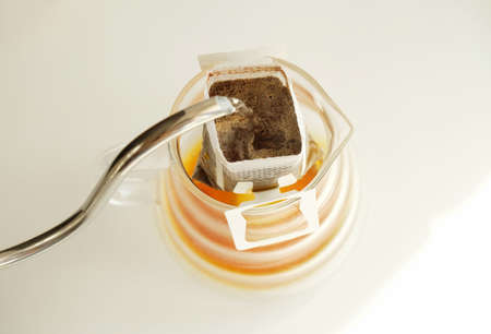 Drip bag coffee brewing process top view. Easy simple brew method, new trend. Specialty aestheticsの写真素材