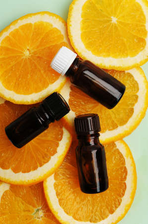 Citrus orange essential oil in dark glass bottles on fresh slices of orange. Cosmetic, healthy...
