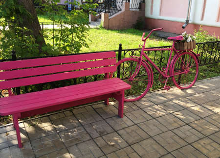 Urban decor pink bench and decorative bicycle as an outdoor flower standの写真素材