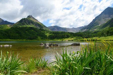landscape. a large beautiful mountain lake with clear water and a mountain range with an ancient extinct volcanoの写真素材