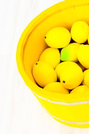 lemons in a large yellow wooden basinの写真素材