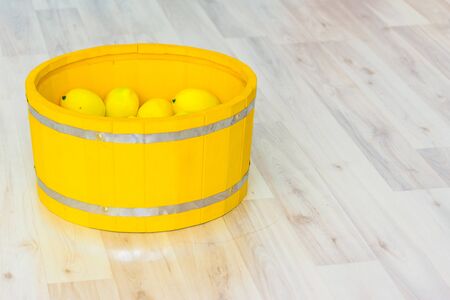lemons in a large yellow wooden basinの写真素材