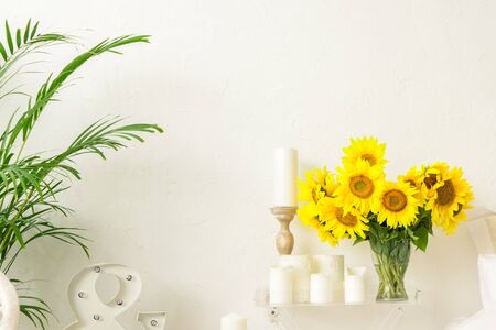 sunflower flowers on the table in a vase in the interior of a bright roomの写真素材