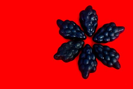 marmalade in the form of grapes on a bright colored backgroundの写真素材