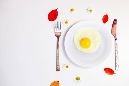scrambled eggs on a white plate and a bright white table with additionsの写真素材