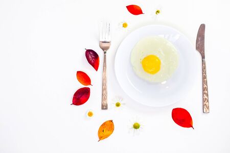 scrambled eggs on a white plate and a bright white table with additionsの写真素材