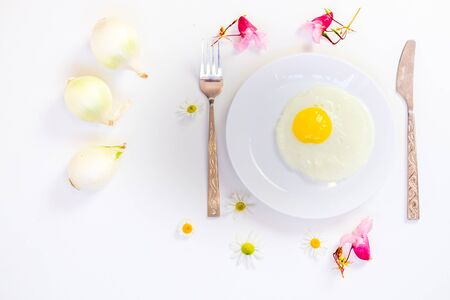scrambled eggs on a white plate and a bright white table with additionsの写真素材