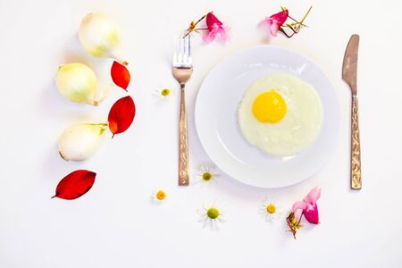 scrambled eggs on a white plate and a bright white table with additionsの写真素材