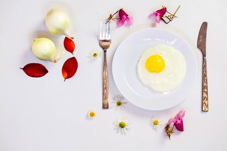 scrambled eggs on a white plate and a bright white table with additionsの写真素材